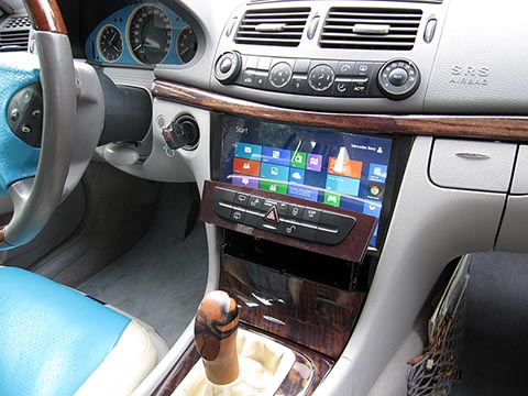 Im Innenraum eines Mercedes Benz E-Klasse W211 ist ein CarPC installiert, 10,1-Zoll funktionierender Bildschirm, eingebaut in die Mittelkonsole, ausfahrbares Bedienfeld mit Tasten.