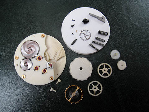 Часовые детали тонкой ручной работы, мосты из слоновой кости, шестерёнки, золотые болтики, баланс.
