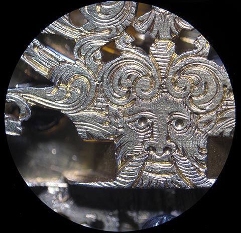 Antike Tischuhr mit Spindelhemmung, angetrieben durch Fusee (Schnecke) und Kette. Detail eines Motivs der skelettierten Unruhbrücke.