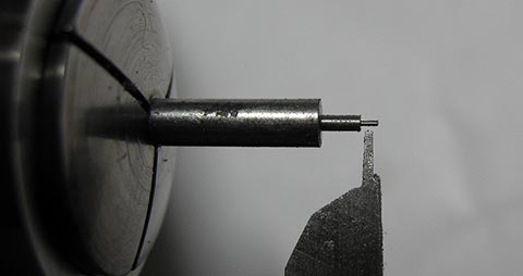 Herstellung des Zapfens mit Welle der Unruhachse auf der Drehmaschine. Antike Tischuhr mit Spindelhemmung.