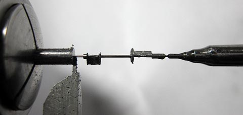 Herstellung des Zapfens mit Welle der Unruhachse auf der Drehmaschine. Antike Tischuhr mit Spindelhemmung, angetrieben durch Fusee und Kette.