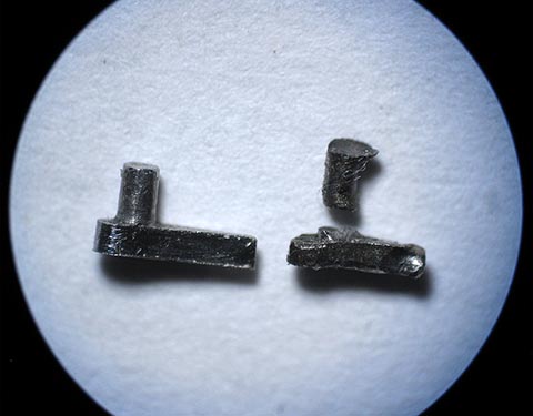 Links neben dem alten gebrochenen Sperrkegel liegt der neu gefertigte Sperrkegel für die Schnecke (Fusée). Antike Tischuhr mit Spindelhemmung.